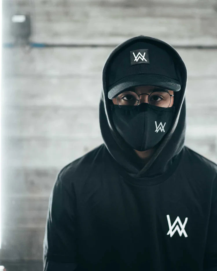 Urban style personified with a black cap and t-shirt ensemble, accented by the white Alan Walker logo, ready for a city adventure.