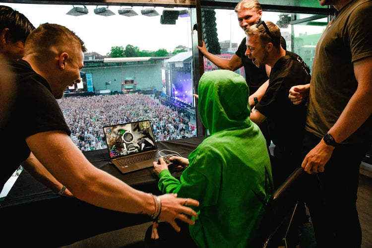 Behind-the-scenes with Alan Walker in the green Stage Hoodie, prepping the DJ booth at a vibrant concert.