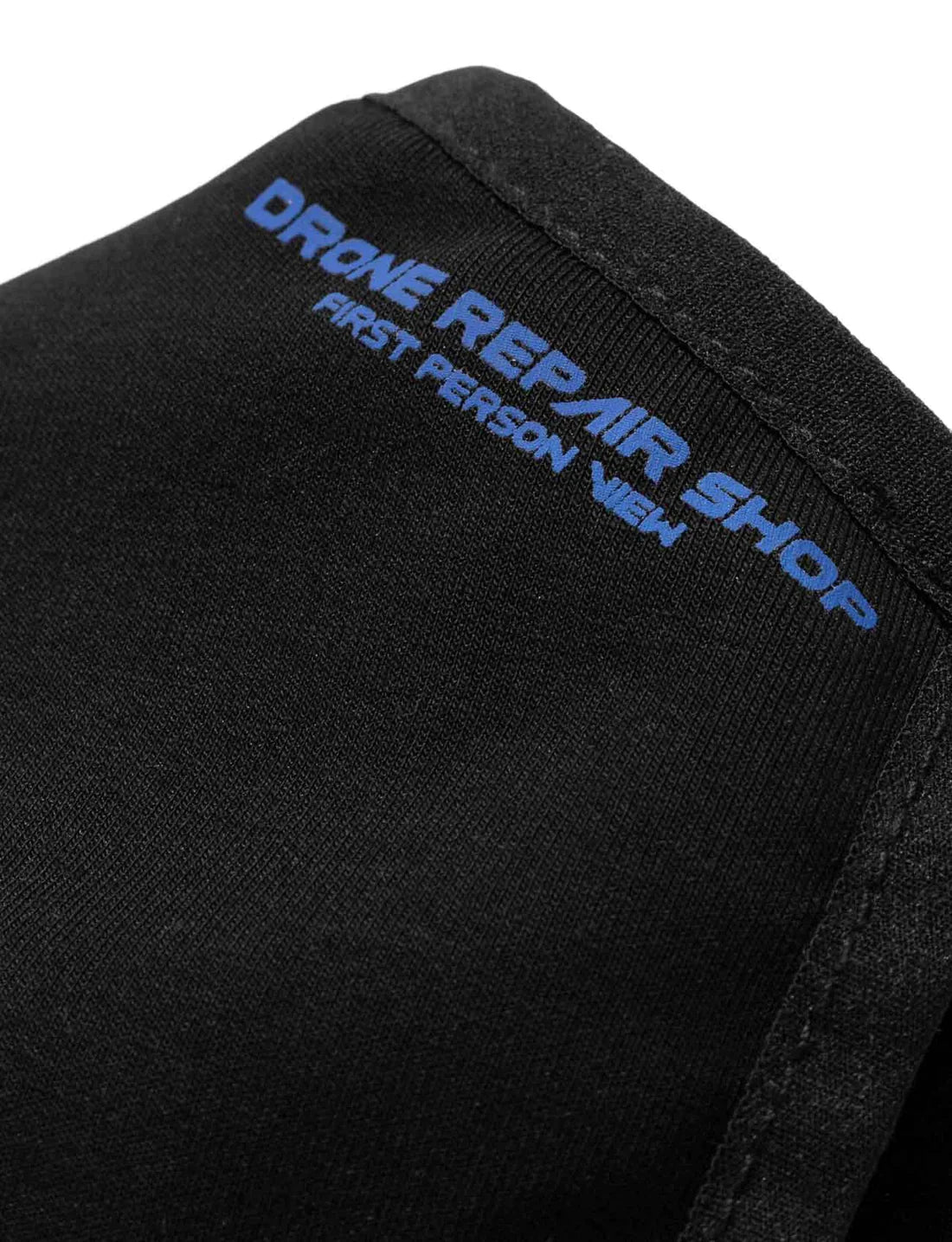 Close-up of the Drone Repair Shop Mask in black, with blue text detail along the edge, highlighting the 'First Person View' design element.