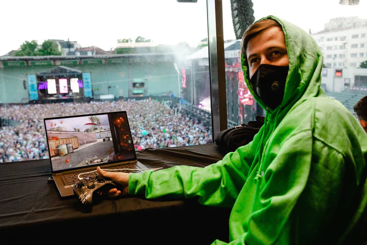 Alan Walker in gaming action, wearing the green Stage Hoodie for a perfect blend of music and gaming culture.