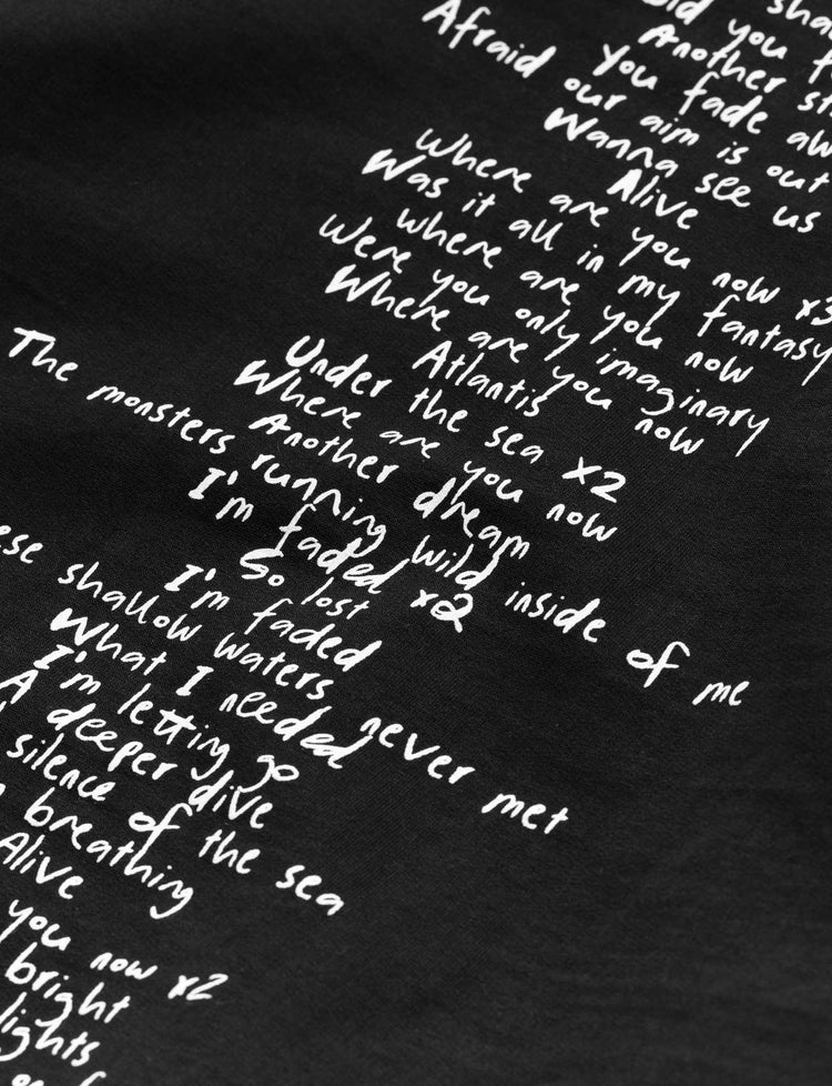 Detailed view of the white lyrics text from Alan Walker's song 'Faded' arranged in a creative pattern on the back of the Faded 2.0 black hoodie.