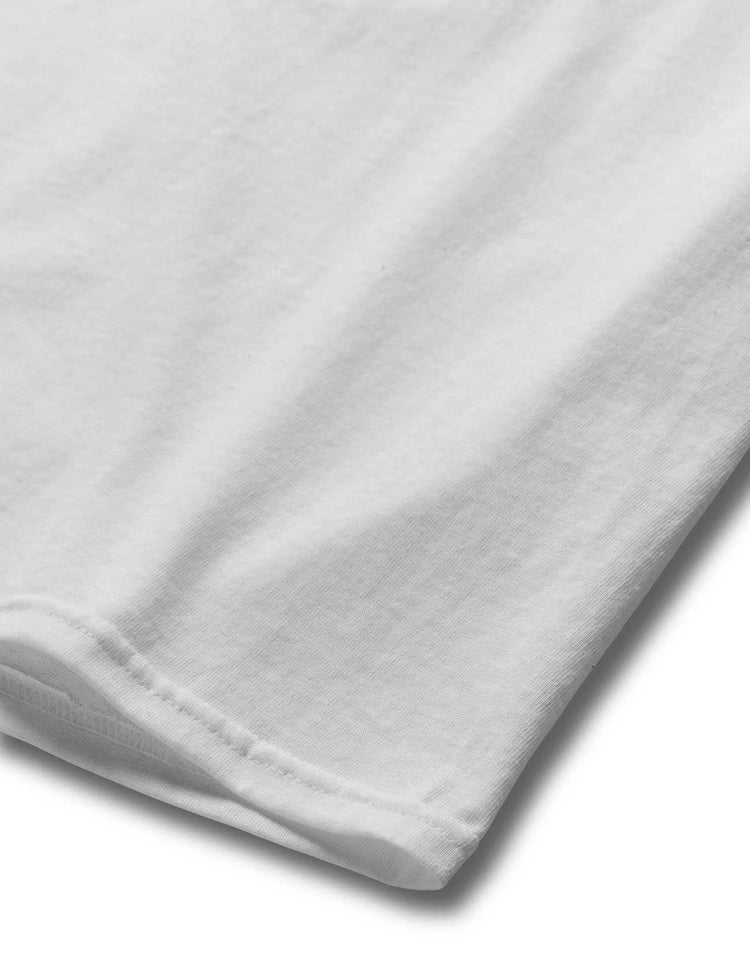 Detail of the hem of Alan Walker's white graphic tee, showcasing the high-quality fabric and finish.