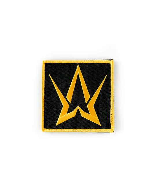 Golden-colored embroidered patch with the Alan Walker logo, finely sewn with small stitches on a black background.