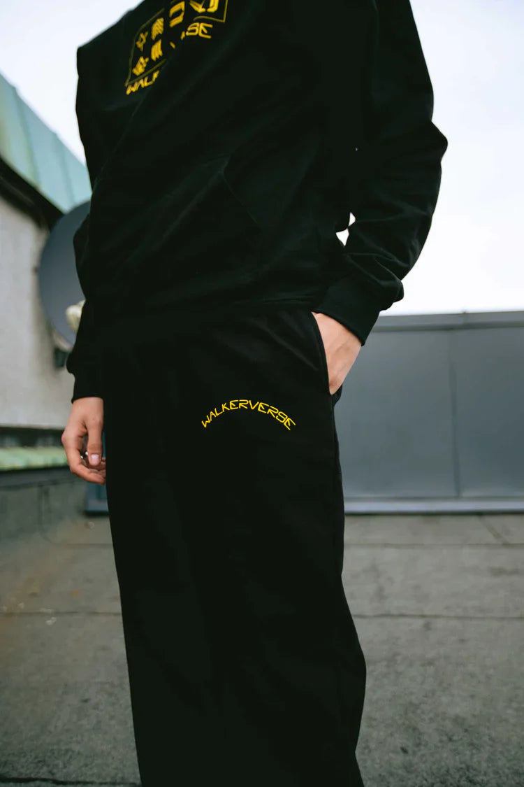 Casual style with black Walkerverse sweatpants worn with hands in pockets.