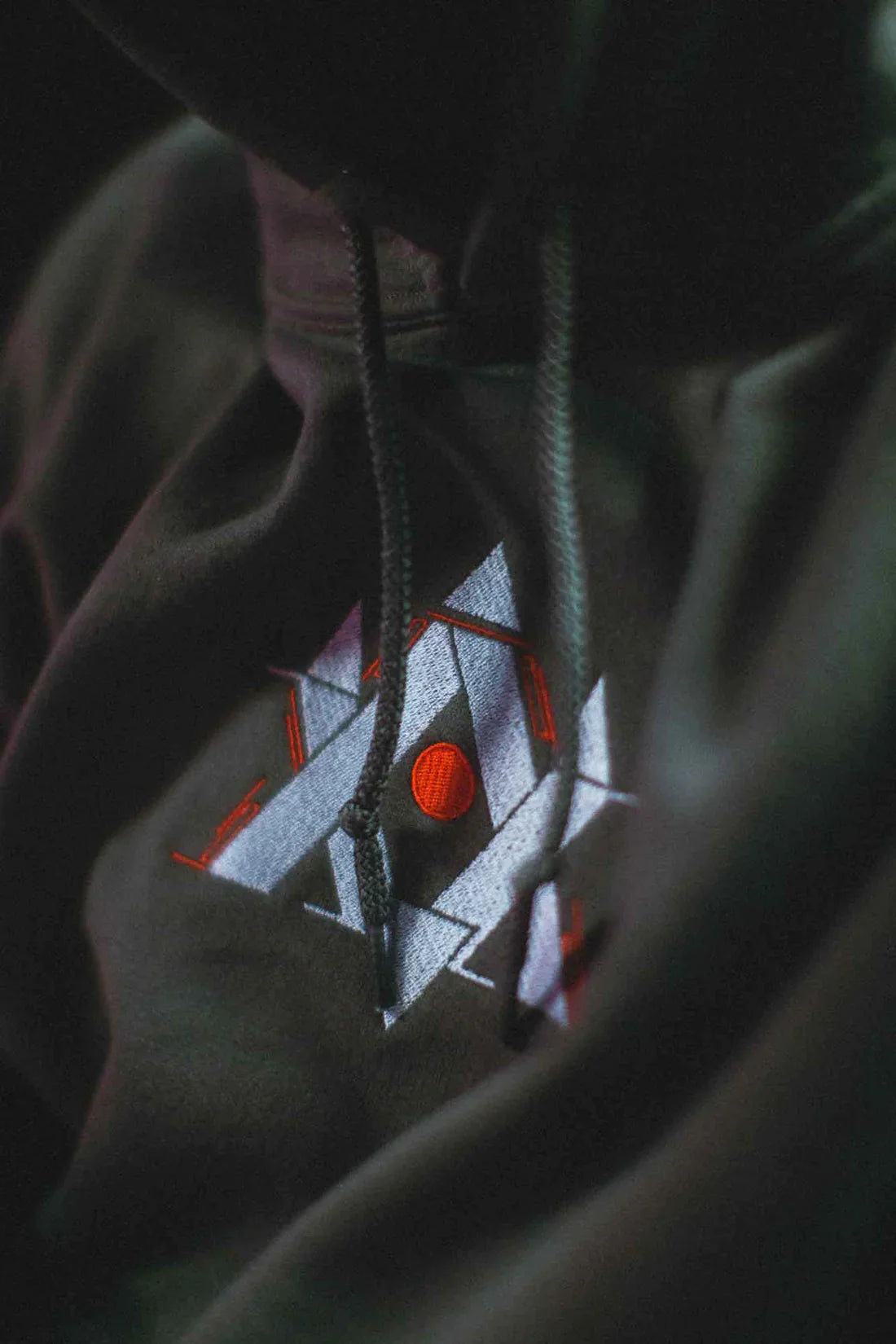 Artistic close-up of Walker Gaming hoodie's drawstrings with a detailed gaming-themed embroidery, highlighting the unique design of Alan Walker merchandise.