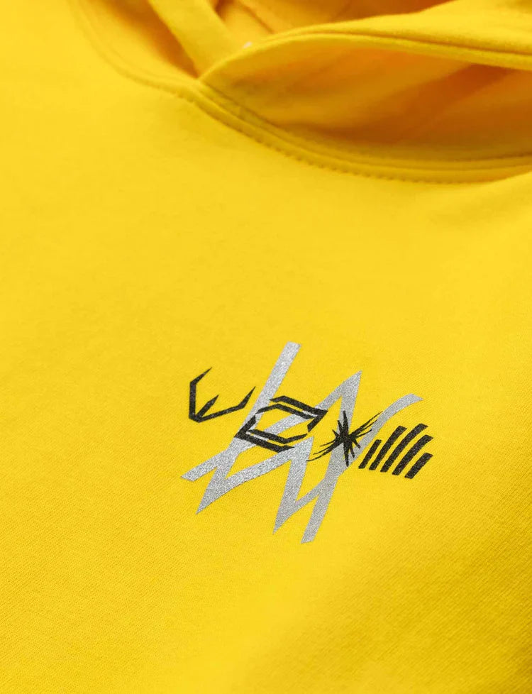 Zoomed-in view of the intricate Alan Walker logo embroidery on yellow kids' hoodie.