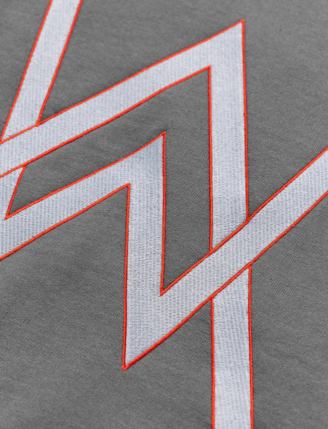 Close-up of the intricate gaming icon design in red and white on the front of a charcoal-gray Alan Walker hoodie.