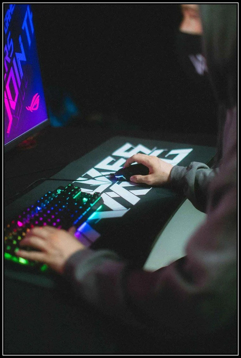 Alan Walker branded gaming mousepad integrated into a dynamic gaming setup with backlit keyboard.