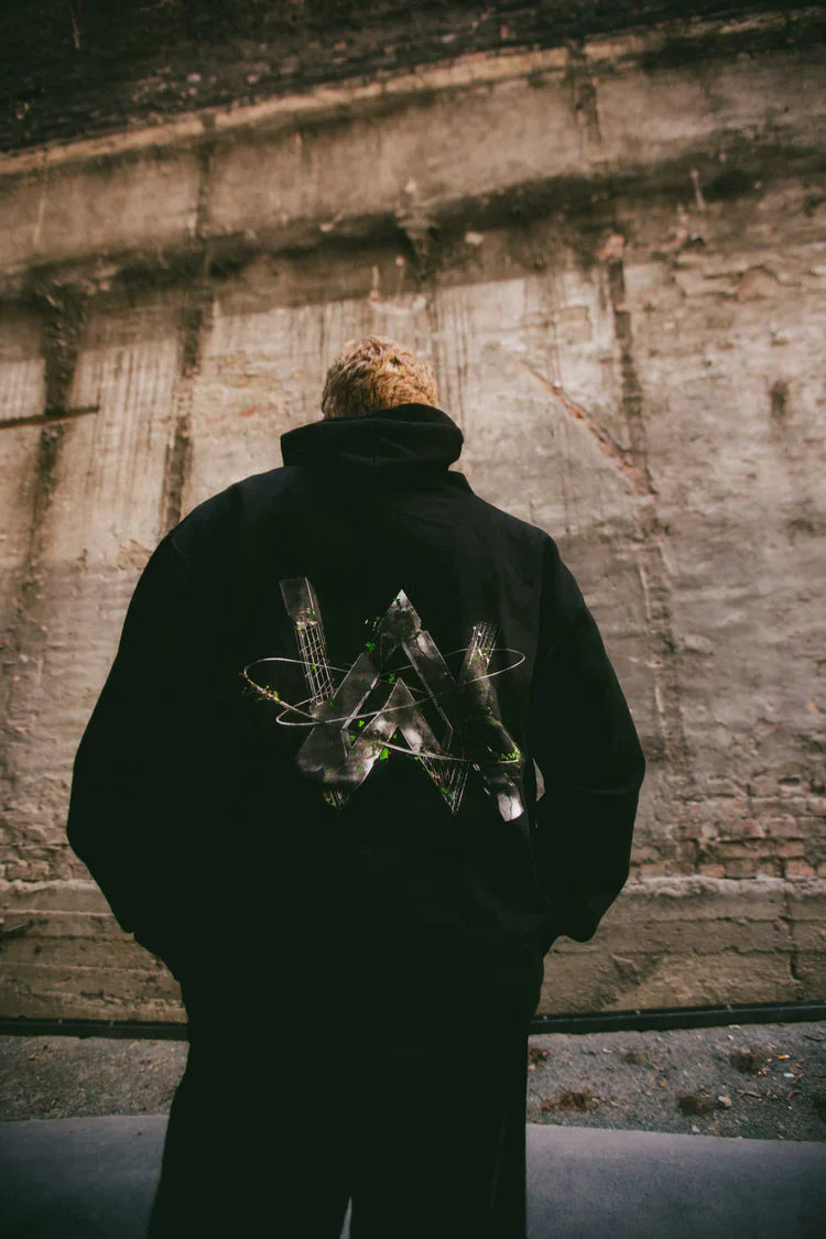 Rear view of a person wearing the 'World We Used To Know' hoodie with a satellite and nature back print.